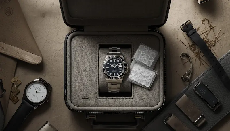 Luxury watch stored in a travel case with microfiber cloth and storage accessories