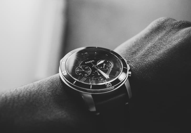 A black and white close-up photograph of a Fossil chronograph watch worn on a wrist