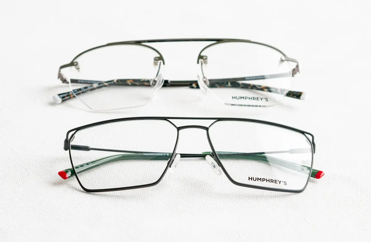 Two pairs of metal designer eyeglasses with lens logo print laying on a white surface for authenticity comparison