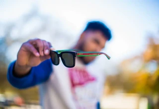 A close-up view of handling luxury Gucci sunglasses properly to prevent frame misalignment and maintain lens quality