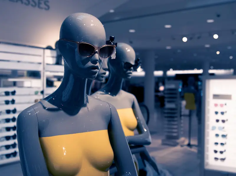 High-end retail display showcasing designer sunglasses on mannequins, highlighting proper frame support and safe storage practices