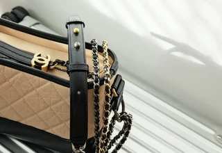 Chanel quilted handbag with iconic CC logo and gold chain strap resting on a luxury suitcase, symbolizing high-end travel and investment-worthy accessory care