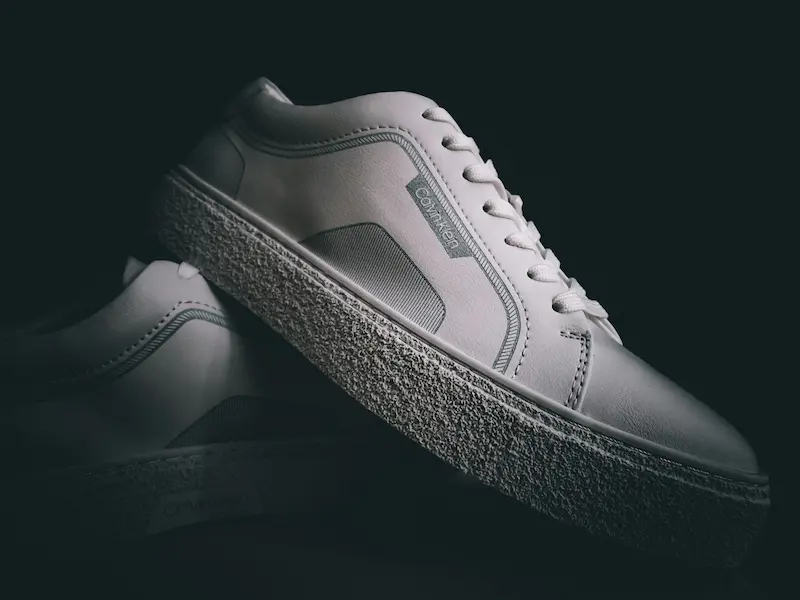 Close-up of premium white leather sneaker midsole detail showing the textured rubber construction that requires proper archival maintenance to prevent hydrolysis and oxidation