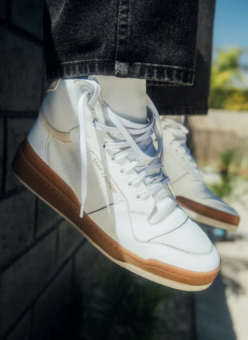 Luxury high-top sneakers with gum sole worn outdoors, illustrating the importance of post-wear decontamination and sole protection protocols