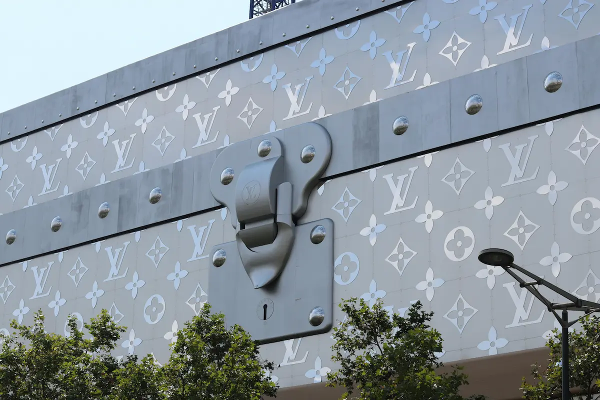 Iconic Louis Vuitton monogram pattern on a luxury brand building facade, representing the heritage and craftsmanship behind LV coated canvas products