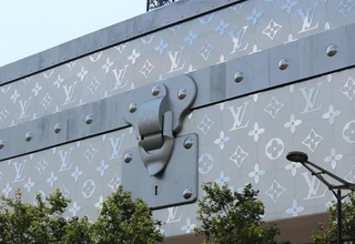 Iconic Louis Vuitton monogram pattern on a luxury brand building facade, representing the heritage and craftsmanship behind LV coated canvas products