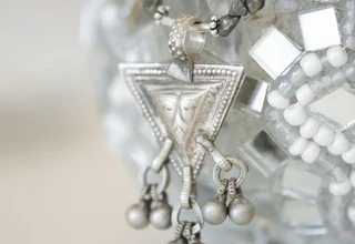 Lustrous sterling silver pocket watch with mirror-like finish surrounded by bokeh light reflections, representing the brilliant result achievable through archival silver restoration protocols