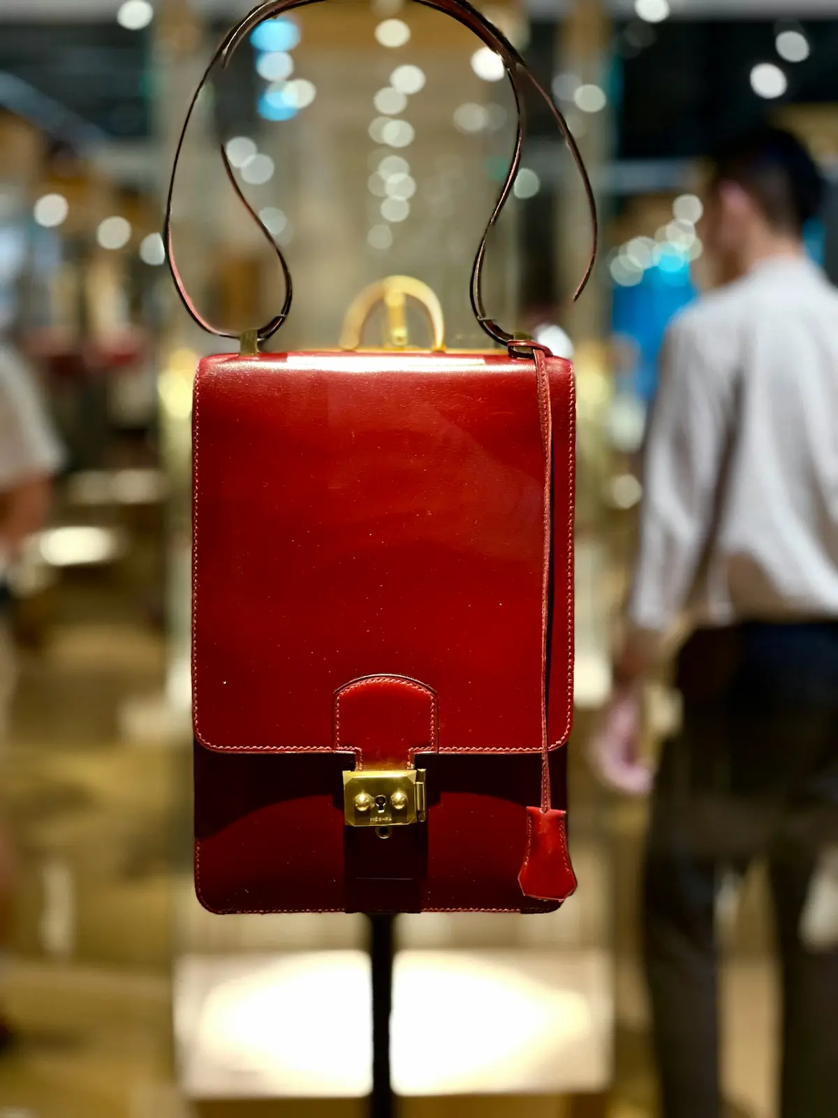 Authentic Hermès leather handbag with smooth glazed finish and gold hardware displayed in a luxury boutique, representing the Box Calf leather type requiring extreme care protocols