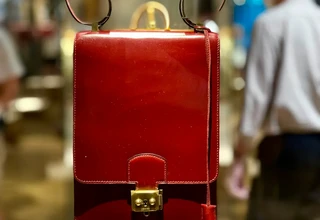 Authentic Hermès leather handbag with smooth glazed finish and gold hardware displayed in a luxury boutique, representing the Box Calf leather type requiring extreme care protocols