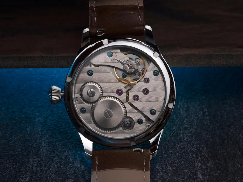 Luxury watch movement visible through transparent case back showing precision mechanism inside