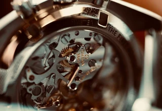 Omega automatic watch movement exposed showing complex gear system that requires regular professional servicing