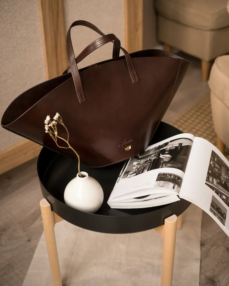 Clean leather tote bag displayed in home setting representing properly cleaned and conditioned leather purse ready for storage after natural cleaning routine