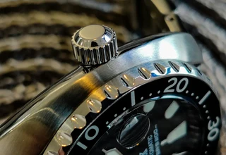 Close-up of stainless steel watch case and crown showing brushed and polished surface finish