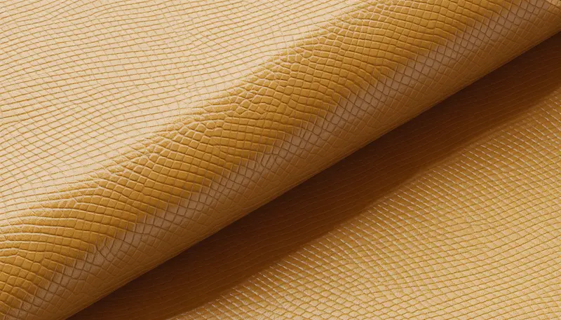 Close-up of Hermès Epsom leather texture showing the iconic cross-hatch embossed grain pattern in gold color.