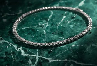 A sparkling, freshly cleaned platinum necklace lying on a green marble